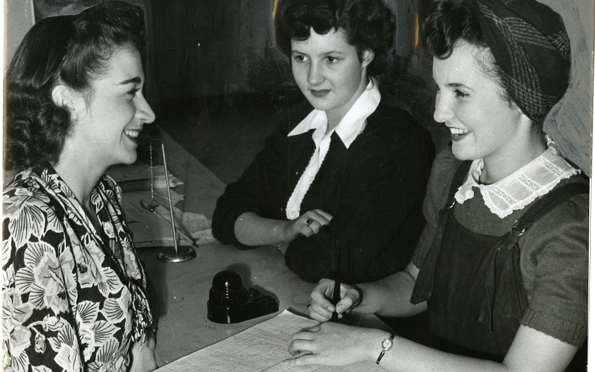 Rosalie Holder (left) signs up Betty Langston and Louise Brundage, duplicator's helpers for Albina Engine & Machine Works, for the "no work--no woo" campaign. Women and men in the company agreed not to date fellow employees who failed to turn in full timecards.